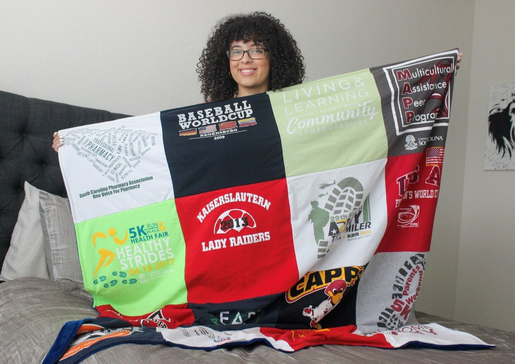 woman holding t-shirt quilt on bed